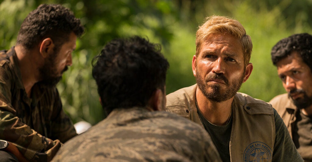 Actor Jim Caviezel sits outside with three other men as he plays the role of Tim Ballard in the movie "Sound of Freedom."