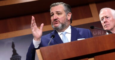 Ted Cruz in a blue suit speaks at a podium