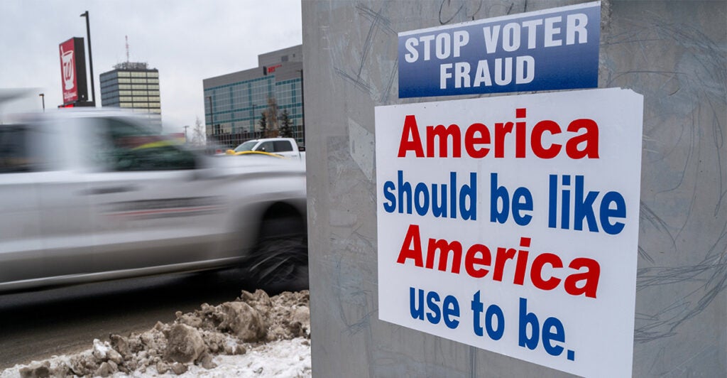 a sticker that says “stop voter fraud” on a streetlight pole