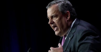 Chris Christie gestures while wearing a suit