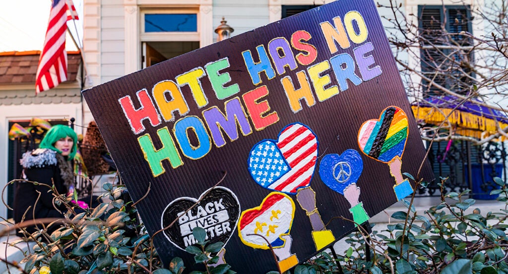 Black sign reads "Hate has no home here" and "Black Lives Matter" in front of a home in New Orleans