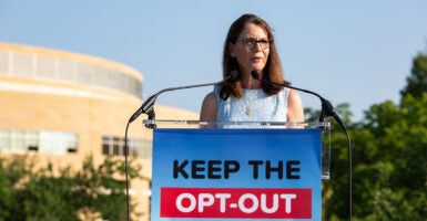 Grace Morrison stands behind a sign reading 