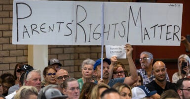 Man holds sign reading 