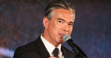 California Attorney General Rob Bonta in a black suit in front of a microphone