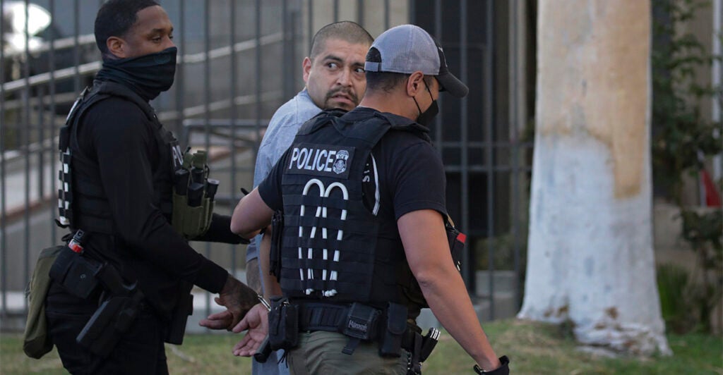 Two agents arrest an illegal alien