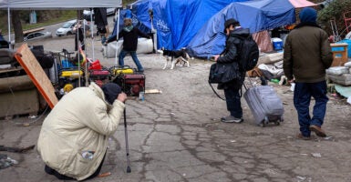 People in a homeless encampment after smoking fentanyl