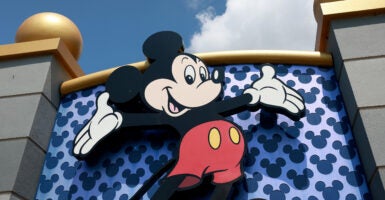 A large outdoor sign with Mickey Mouse at the entrance of Disney World