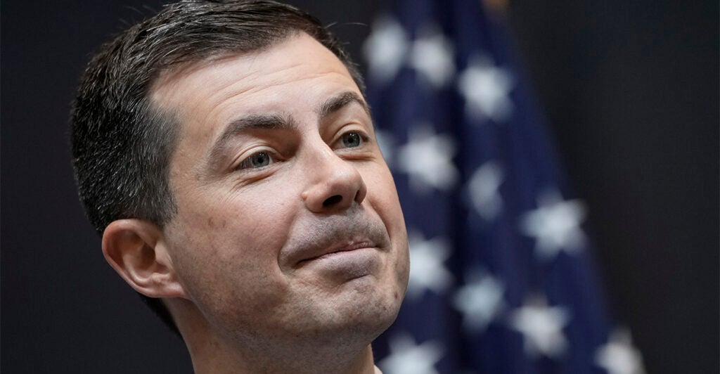 Secretary Pete Buttigieg in front of American flag