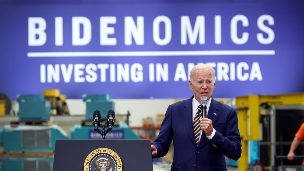 Joe Biden speaks in front of a sign reading "Bidenomics."