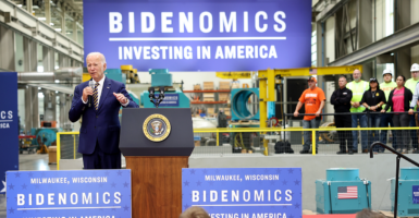 President Joe Biden speaks in front of a sign reading 