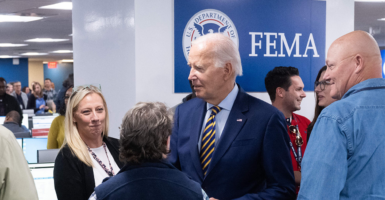 Joe Biden in a suit in front of the Federal Emergency Management Agency (FEMA) logo