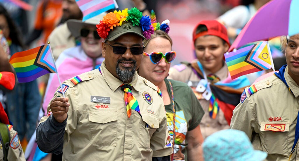 Boy Scouts in uniform march in pride parade