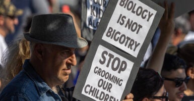 A man holds a sign reading 