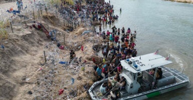 Illegal aliens are seen along the shore of the river in Eagle Pass, Texas.