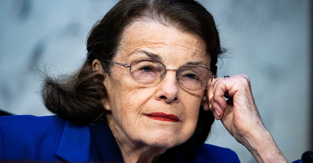 Sen. Dianne Feinstein rests her head on her hand while listening during a hearing.