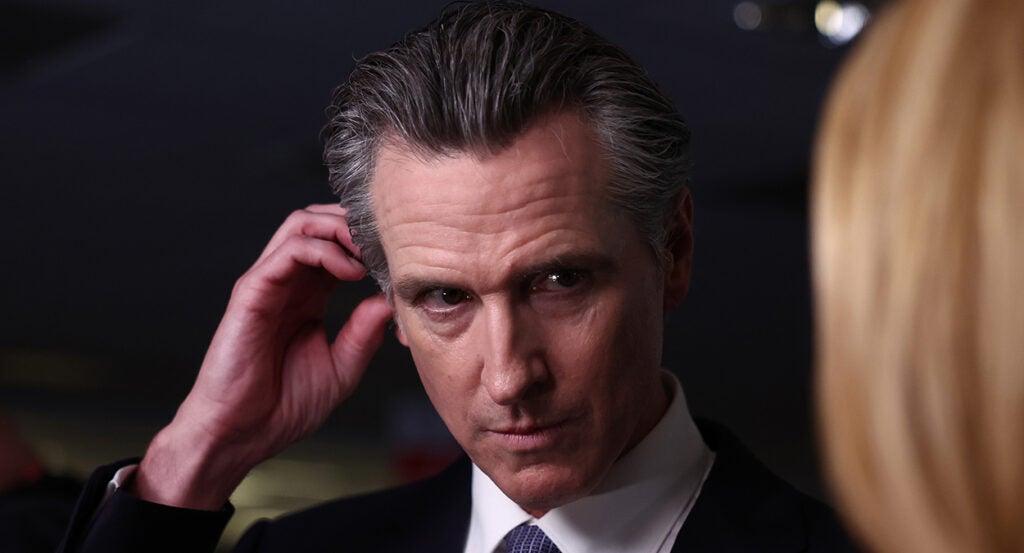 Gavin Newsom in a suit looks skeptical in a suit.