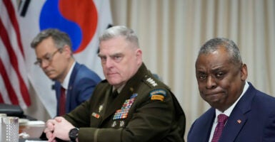 Mark Milley in uniform sits next to Lloyd Austin in a suit