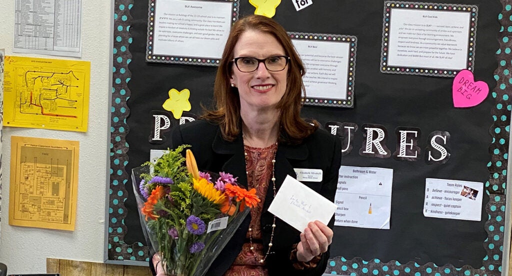 Elizabeth Mirabelli holds a thank-you card in her classroom.