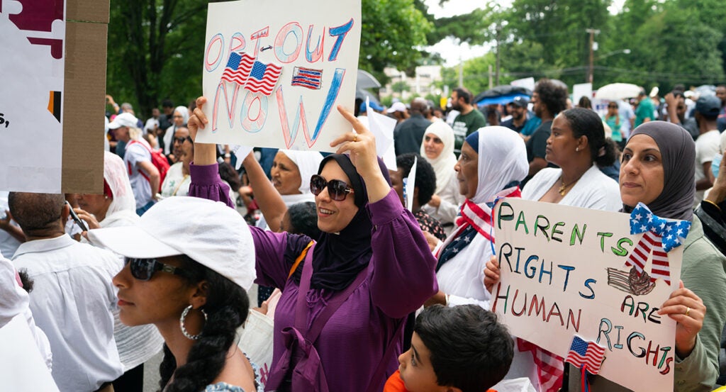 Maryland parents hold signs reading "Opt-out Now" and "Parents Rights Are Human Rights" outside Montgomery County Public Schools