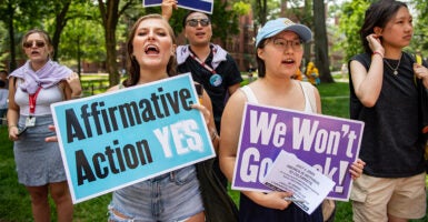 Students hold signs protesting for affirmative action