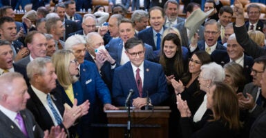 House Speaker nominee Rep. Mike Johnson speaks at a podium beside fellow Republican House members