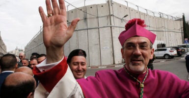 The Latin Patriarch of Jerusalem reportedly said Monday that he would go to great lengths to obtain the freedom of those children captured by Hamas terrorists, even offering himself as an exchange for their safety. Pictured: Archbishop Pierbattista Pizzaballa, Apostolic Administrator of the Latin Patriarchate of Jerusalem, gestures upon arrival through an Israeli checkpoint to attend Christmas eve celebrations in the West Bank city of Bethlehem December 24, 2017. (Photo by HAZEM BADER/AFP via Getty Images)