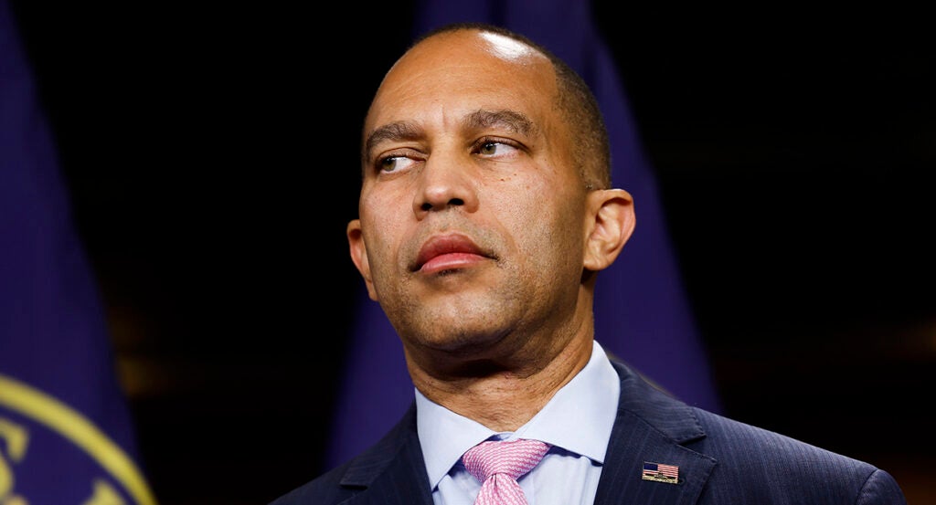 Hakeem Jeffries in a blue suit looks to the left