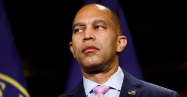 Hakeem Jeffries in a blue suit looks to the left