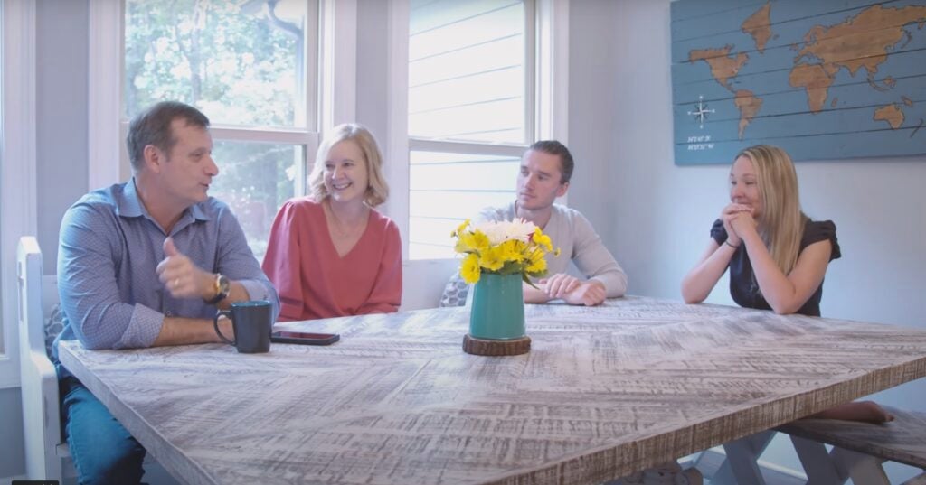 Scott and Jeanne Hamilton sit with their son Jordan Hamilton and Erin Boggs at a wooden kitchen table.