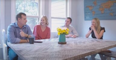 Scott and Jeanne Hamilton sit with their son Jordan Hamilton and Erin Boggs at a wooden kitchen table.