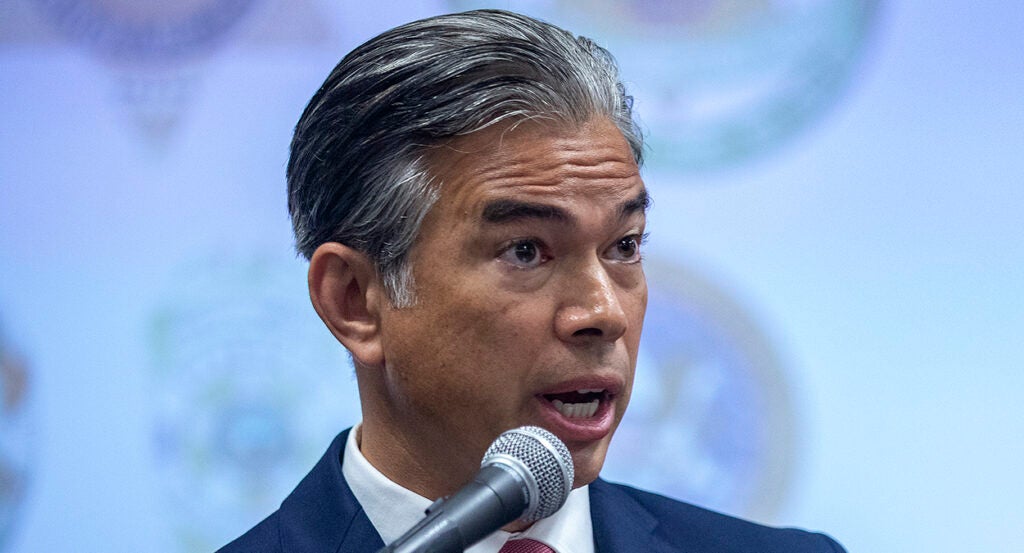 Rob Bonta speaks at a news conference in a blue suit