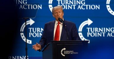 Former President Donald Trump speaks in front of a Turning Point USA logo