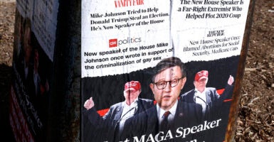 Posters outside in Washington, D.C., cite alarmist headlines about House Speaker Mike Johnson