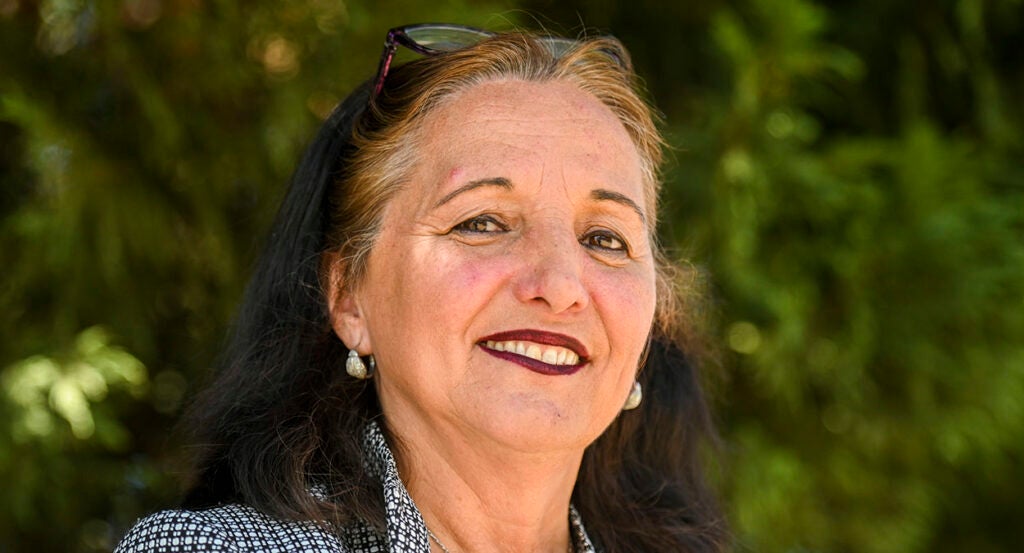 Buta Biberaj smiles while wearing earrings