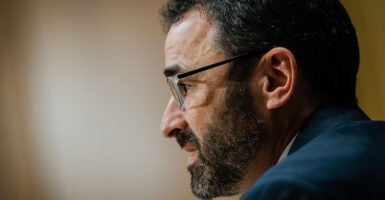 IRS Commissioner Danny Werfel in a suit wearing glasses and a salt-and-pepper beard