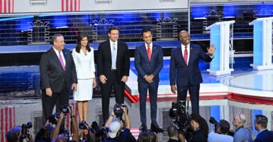 Five podiums are seen on the debate stage set with a White House backdrop.