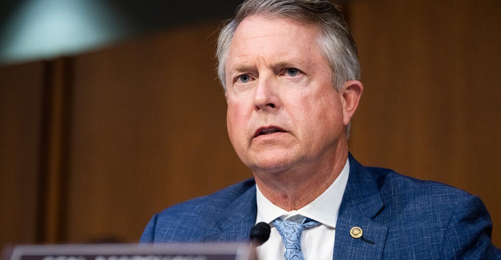 Sen. Roger Marshall speaks at a hearing in a blue suit and light blue tie.