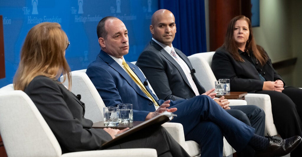 Bob Good, Erik Baptist, Christina Francis sit on stage at the Heritage Foundation