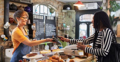 a woman smiles while making a purchase at a bakery