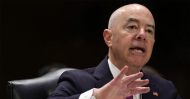 Secretary of Homeland Security Alejandro Mayorkas Sitting at a table testifying before the Senate