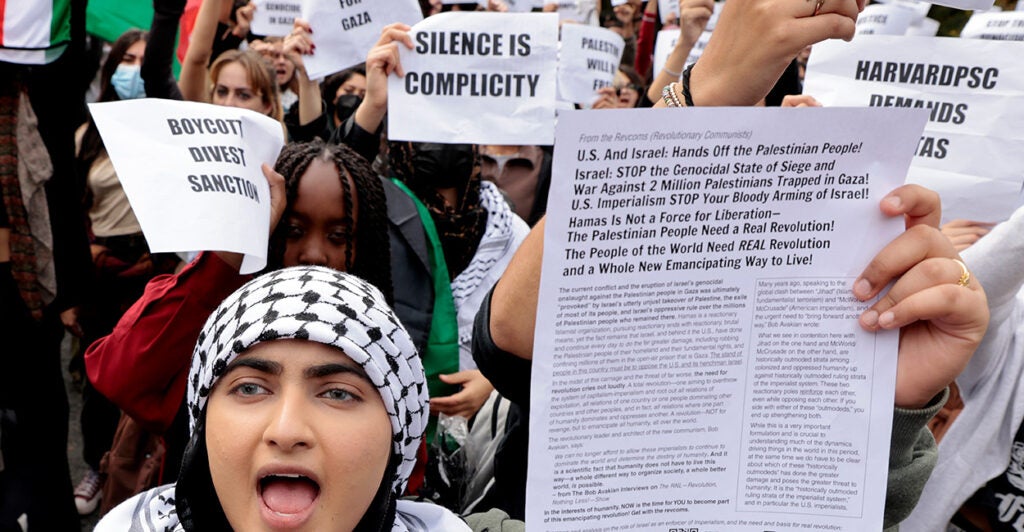 Pro-Palestinian protestors yell and carry signs blaming Israel for Hamas attack