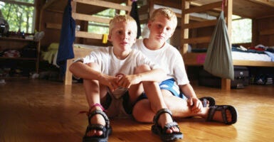 Two young blond boys in a room with bunk beds