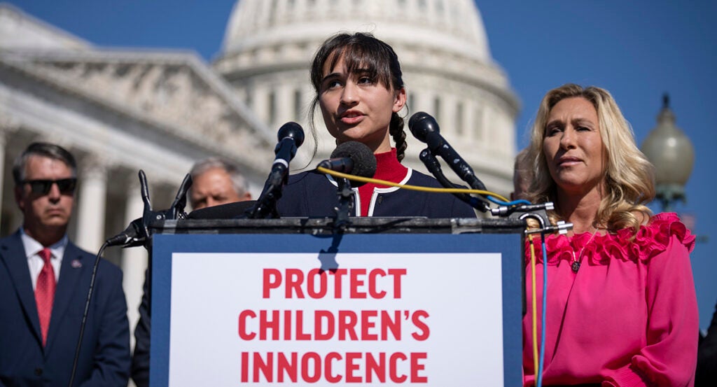 Detransitioner Chloe Cole speaks wearing red and blue at the Capitol building