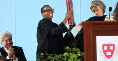 Harvard President Claudine Gay holds a book in black robes