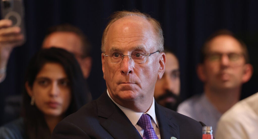 BlackRock CEO Larry Fink in a suit with a blue tie looks left