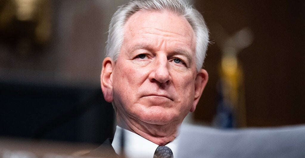 Sen. Tommy Tuberville looks ahead wearing a suit and tie.