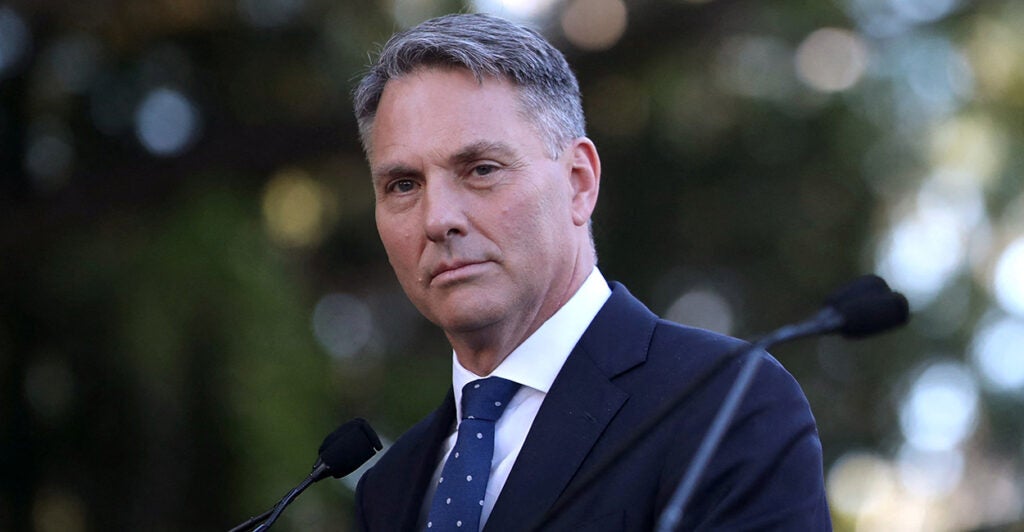 Australian Defence Minister Richard Marles Speaks at a microphone outdoors