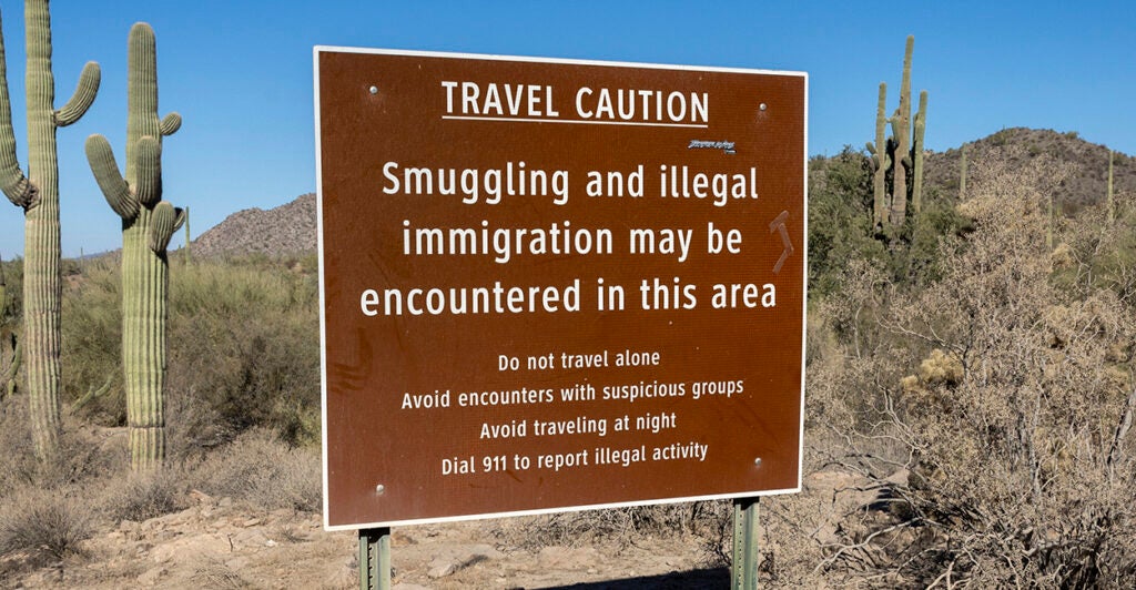 A sign warning of smuggling and illegal immigration in the Arizona desert.