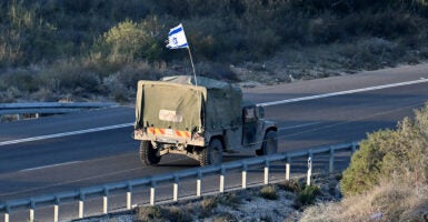 a truck drives with an israel flag