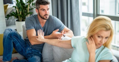 Young couple arguing on couch.